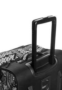 Czarna walizka na kółkach z wysuwaną rączką, z geometrycznym białym wzorem. Teksturowany materiał, wyściełane uchwyty i akcenty suwaka.