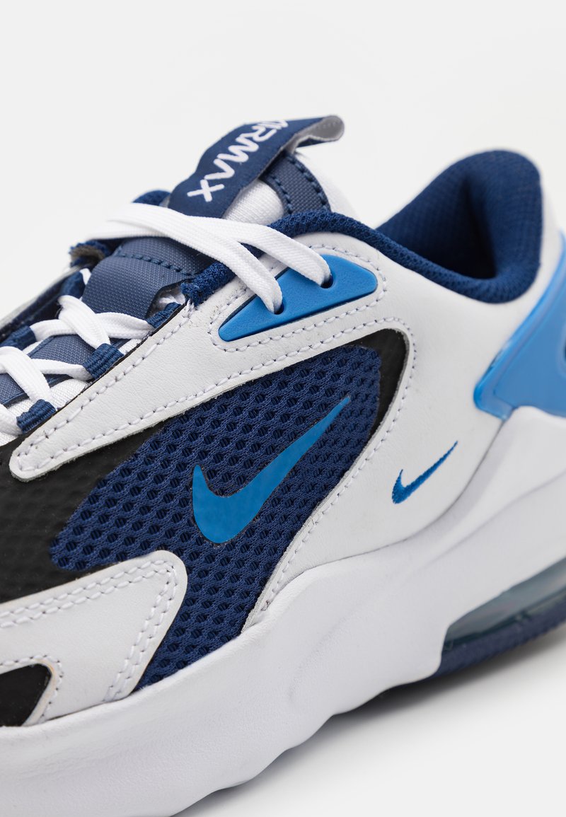 Zapatillas Nike Air Max con un diseño en cuero blanco, malla negra y textil azul marino. Incluye acentos azules y cordones blancos planos.