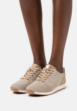 Baskets légères beige avec une tige en maille, un design texturé et des accents dorés. Dotées de lacets plats et d'une semelle en caoutchouc.