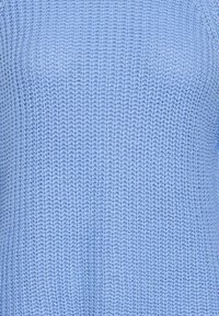 Gros plan d'un tissu tricoté bleu clair avec un motif côtelé vertical texturé.
