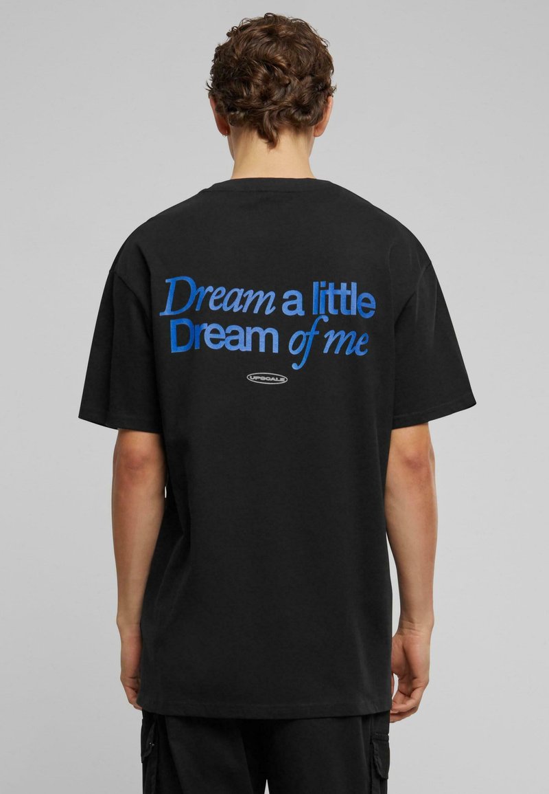 Sort bomulds T-shirt med blå tekst på ryggen, der står: "Dream a little Dream of me." Klassisk rund halsudskæring og afslappet pasform.