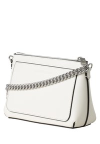 Bílá kabelka Calvin Klein se stříbrným řetízkovým popruhem, přední kapsou a horním zipem na bílém pozadí.