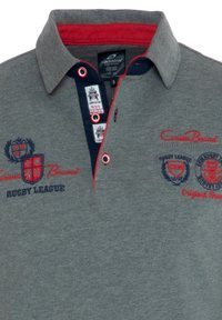 Grå polo t-shirt med røde og marineblå accenter, med broderede logoer, krave og knaplukning. Blødt bomuldsstof.