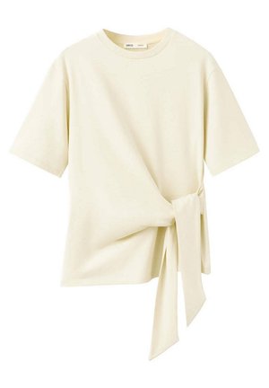 Top crème à manches courtes avec un col rond et un détail de lien en tissu asymétrique sur le côté droit.