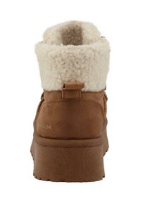 Bottes à chevilles marron avec un col moelleux de couleur crème et une semelle texturée ; équipée d'une languette pour un enfilage facile.