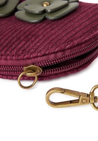 Burgundy kordurového pouzdra se zelenými květinovými akcenty, bronzovým zipem a klipovým kováním. Texturovaný povrch s žebrovaným vzorem.