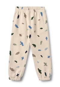 Pantalones de chándal de algodón beige con un patrón multicolor de siluetas de animales en azul, verde y marrón, con puños y cinturilla elásticos.