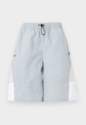 Pantalones cortos deportivos de color gris claro con paneles laterales blancos, cinturilla elástica y cordón negro, mostrados sobre un fondo liso.