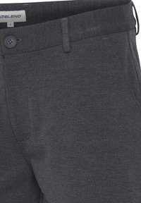 Dark gray trousers with button closure, belt loop, and side pockets, showing fabric texture and a size label "L."