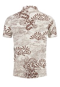Camisa de manga corta en tela crema con un patrón abstracto marrón de olas, abanicos y un tigre. Diseño con cuello y textura suave.