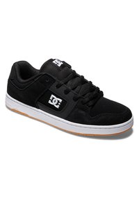 Čierne skateboardové topánky so zvrškom z semišu, polstrovaným jazykom a šnurovacím dizajnom. Obsahujú biele logo na boku a gumovú podrážku.