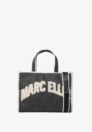 Sac fourre-tout en feutre gris avec des accents crème et des lettres en relief. Dispose de deux anses noires avec détails du logo et une forme rectangulaire.