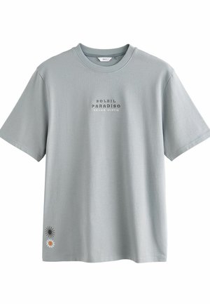 Svijetlosivi pamučni T-shirt s kratkim rukavima, na kojem se nalaze natpis "SOLEIL PARADISO TEXAS AUSTIN" te grafika suncokreta i cvijeta na rubu.