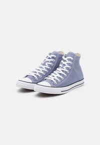Höga sneakers i ljuslila kanvas med vita snören, gummitåhuvud och svarta detaljer på sulan. Har en klassisk design.
