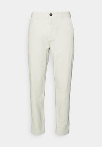 Ljust beigefärgade bomullsbyxor med rak passform, med knappstängning fram och två sidofickor. Texturerad yta med subtila åsar.