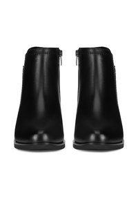 Čierne členkové čižmy vyrobené z hladkej kože, s bočnými zipsami, zaoblenou špičkou a minimalistickým dizajnom s nízkym opätkom.