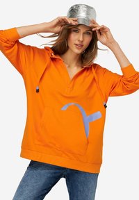 Oranje pullover hoodie met een halve rits, grote voorkant zak en blauw grafisch ontwerp. Heeft drawstrings met zwarte tips. Metalen zilveren pet.