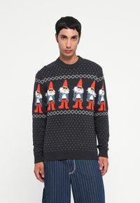 Dunkel gestrickter Pullover mit weißem Punktmuster und rotem Gnome-Design auf der Brust. Mit geribtem Rundhalsausschnitt und Bündchen.