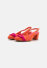 Slingback-kengät oranssista nubukista, jossa on vaaleanpunainen kangasrusetti. Varusteena lohkokiilakorko ja pyöreä kärki.