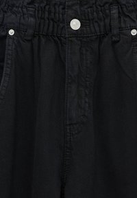 Zwarte denim broek met elastische tailleband, zilveren knoopsluiting, voorzakken en riemlussen.