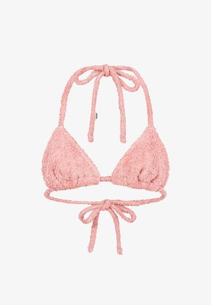 Młoda kobieta o blond włosach, ubrana w różowy, puszysty kapelusz typu bucket oraz pasujący top bikini, z naszyjnikiem z koralików i tatuażami na klatce piersiowej oraz ramieniu.