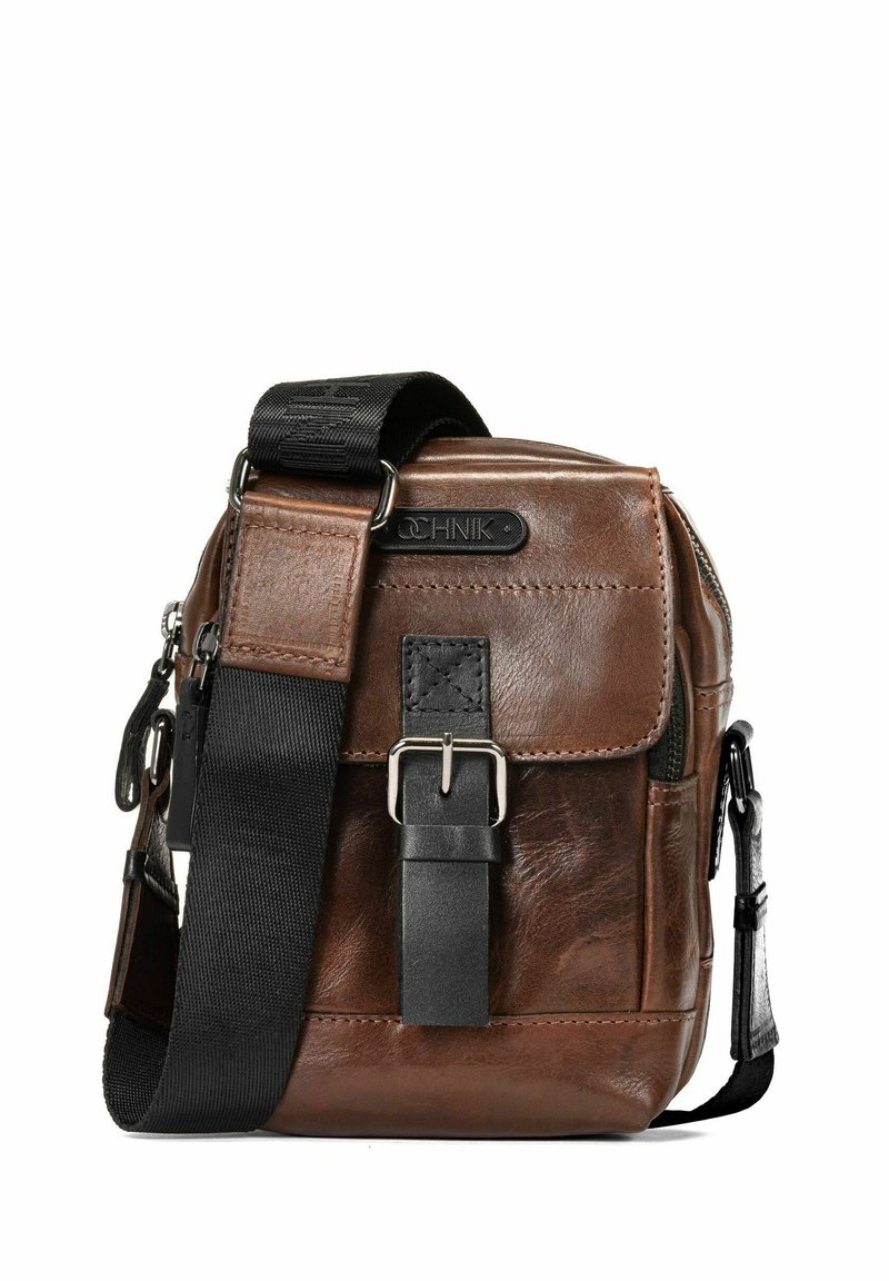 Brązowa skórzana torba na ramię z teksturowanym wykończeniem, regulowanym czarnym paskiem z tkaniny, srebrnymi detalami i zapięciem na klamrę z przodu.