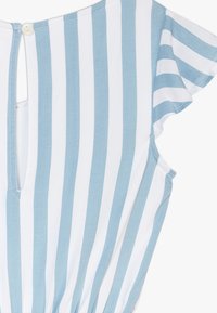 Pasiasty top z miękkiego niebieskiego i białego materiału, z krótkimi falbankami, zapięciem na guziki z tyłu i okrągłym dekoltem.