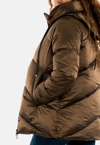 Doudoune marron avec capuche, présentant un motif matelassé, des poches latérales et une fermeture éclair à l'avant. Conçue en matériau brillant et lisse.