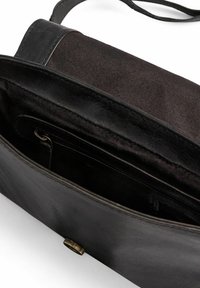 Svart läderhandväska med en texturerad tygfoder, magnetknäppning och innanför ficka med dragkedja för säker förvaring. Enkelt utförande.