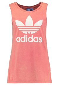 Ärmlös korallrosa Adidas linne med stor vit trefoil-logotyp och "adidas" text på framsidan, rundad halsringning, avslappnad stil.