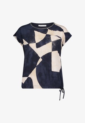 Kortærmet bluse med abstrakt sort og beige geometrisk print og en bindedetalje i siden ved kanten.