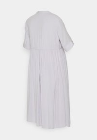 Vestido lilás claro com mangas curtas, cintura franzida e tecido texturizado com riscas verticais. Silhueta em A até ao joelho.