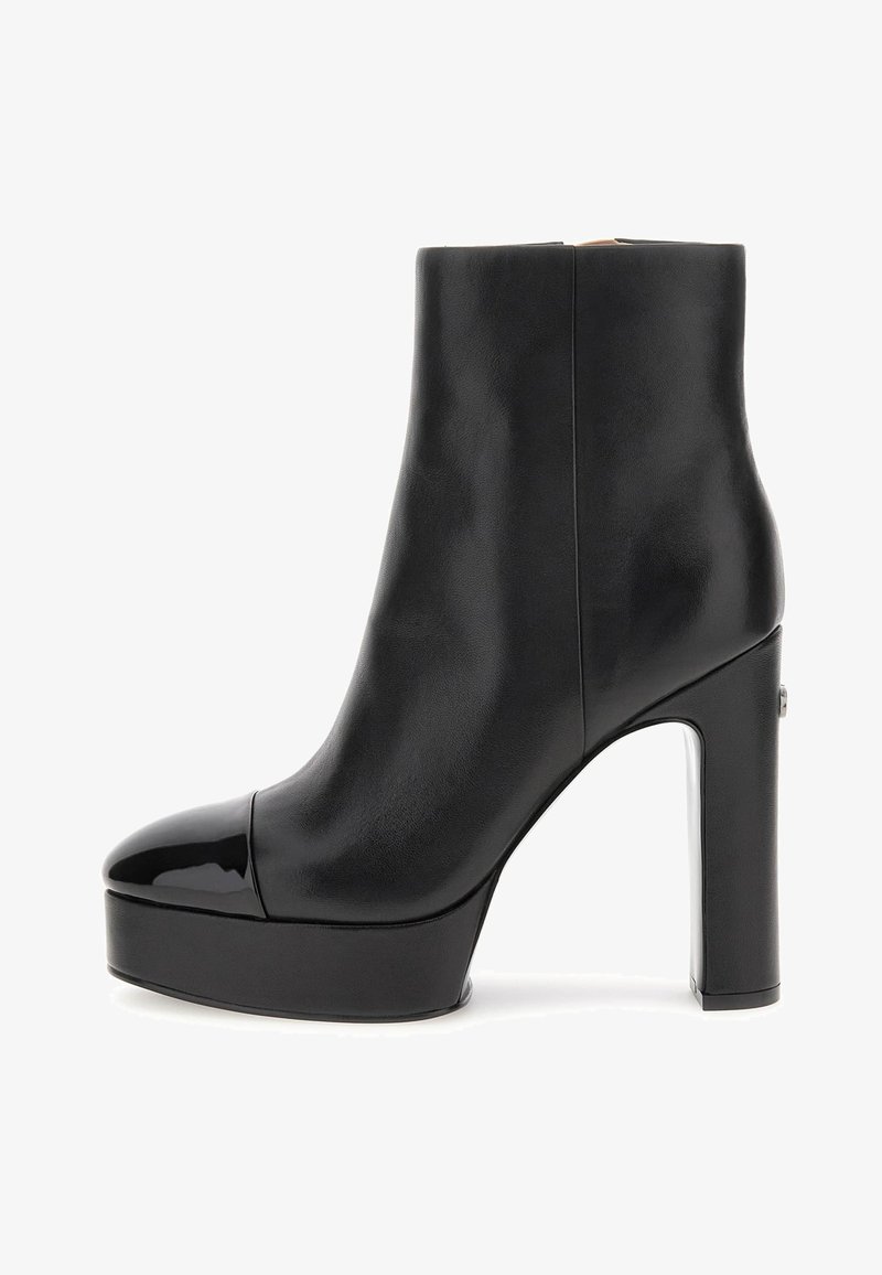 Schwarze Lederstiefelette mit einer Lacklederkappe, klobigen Plateausohle und hohem Blockabsatz; glatte Textur und minimale Details.