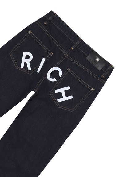 Jeans in denim blu scuro con tasche posteriori caratterizzate da grandi lettere bianche "R," "I," "C," e "H," e un'etichetta di marca in pelle nera sulla vita.
