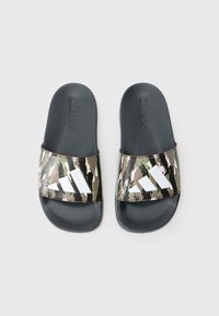 Svarte sandaler med camouflagestrikk og en hvit logo. Stroppen har en blank finish, mens fotbeden er teksturert for grep.