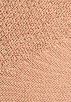 Ύφασμα σε χρώμα ροδάκινου με μαλακό, υφασμένο πλέξιμο. Η επιφάνεια διαθέτει ελαφριά λάμψη, μεταβαίνοντας από ριμπ ύφασμα σε λείο φινίρισμα.