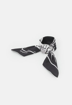 Černobílý šátek z potištěné látky volně uvázaný s špičatými konci, nesoucí částečné abstraktní vzory a text značky v jednom rohu.