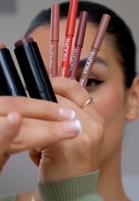 Seks leppennere og to leppestifter, med et utvalg av farger fra dyp burgunder til myk nude, presentert med en svart emballasjedesign.