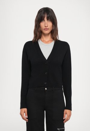 Svart kort cardigan med v-hals, lange ermer og fem-knappers lukking. Laget av et mykt materiale med ribbestrikket kant og glatt tekstur.
