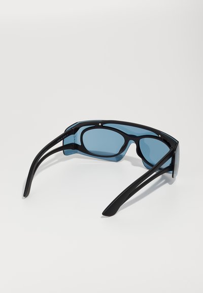 Ochelari negri cu lentile albastre mari și rotunde. Brațe subțiri cu un finisaj mat. Prezintă un design cu pod dublu pentru o stabilitate suplimentară.