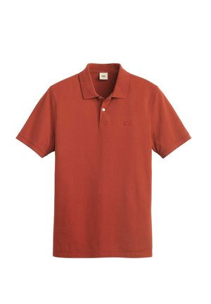 Röd polotröja i mjukt bomull, med klassisk krage, korta ärmar och en liten, broderad logotyp på vänster bröst.