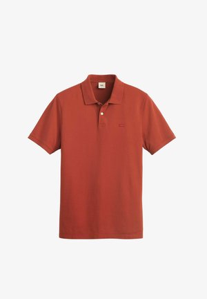 Red polo shirt made of soft cotton, featuring a classic collar, short sleeves, and a small, embroidered logo on the left chest.