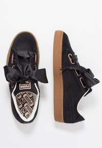 Černé kordurové tenisky mají silnou gumu, saténové černé tkaničky a měděné očky. Vnitřní stélka má vzorovaný design.