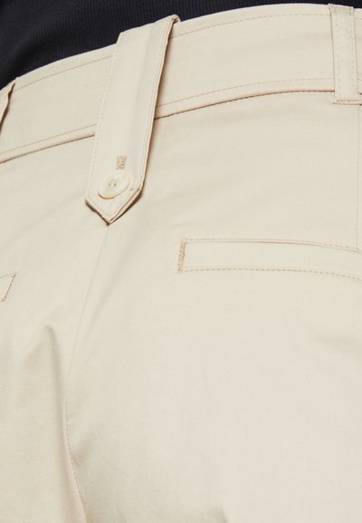 Beige broek met een rechte snit, voorzien van een knoopsluiting en gestikte pocketdetails. Gemaakt van een katoenmix, met een soepele textuur.