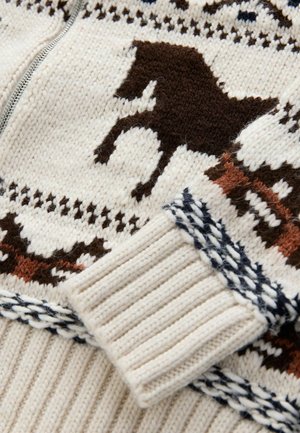 Knitted zip sweater in cream, featuring brown horse motifs and geometric patterns. Ribbed cuffs with navy detailing. Soft texture.