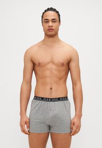 Graue Baumwollboxershorts mit einem schwarzen Bündchen, das das Logo "PIER ONE" trägt. Die Passform ist lässig mit einem Knopfdetails auf der Vorderseite.