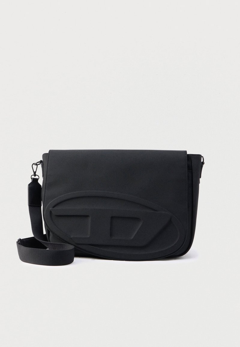 Schwarze Umhängetasche aus strapazierfähigem Stoff mit glatter Oberfläche, Klappe zum Verschließen und gepolstertem Vorderteil mit geformten Akzenten.