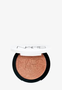 Compatta di bronzer pressato con coperchio bianco e base nera. La polvere è di un bronzo luccicante, con logo in rilievo. Forma rotonda, texture metallica.