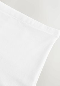 Fehér pamutszövet sima textúrával és finom fényességgel. A szélén síkvarrással rendelkezik, mely tiszta, minimalista dizájnt mutat.