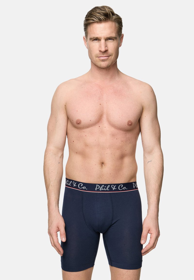 Mörkblå kalsonger i boxerstil med en mjuk elastisk midjeresår som har "Phil & Co." i kontrasterande bokstäver. Tillverkade av bomull med en slät textur.